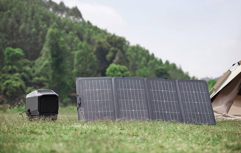 Aer condiționat și panouri solare pliate pe iarbă lângă cortul de camping