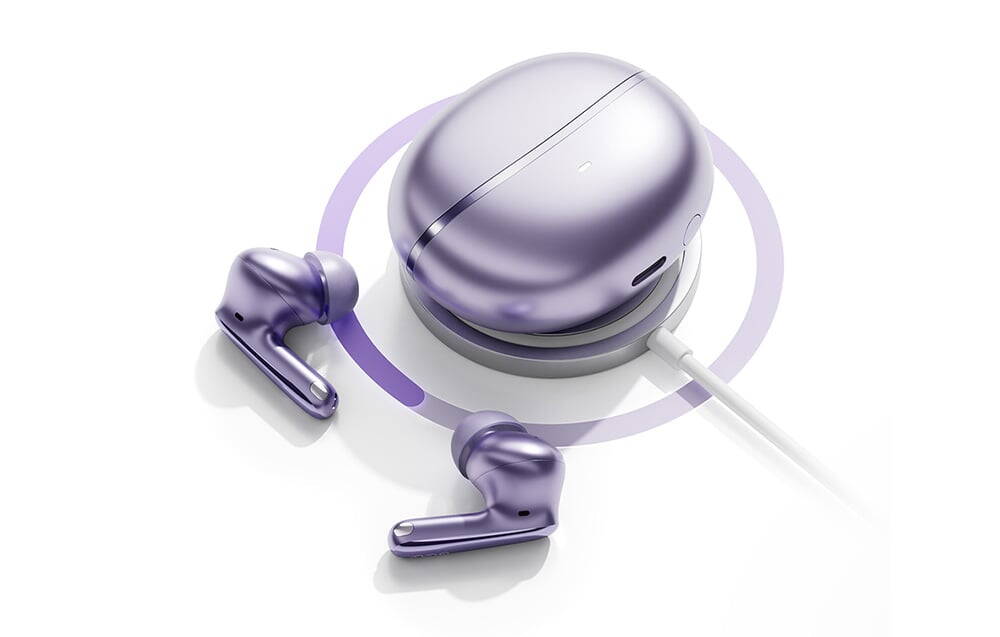 Căști fără fir violet și carcasă de încărcare plasate pe un încărcător fără fir rotund